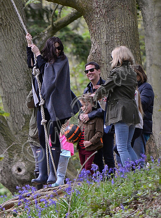 Actress Liv Tyler on rope swing wearing grey poncho and blue Hunter wellies