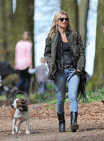 Supermodel Kate Moss wearing military style jacket, skinny jeans and cowboy boots takes a walk with her dog Archie in the woods