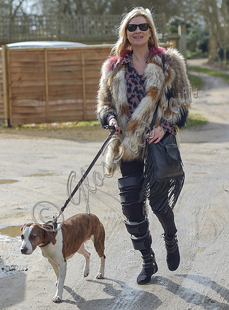 Kate Moss wearing Isabel Marant fur jacket and suede ankle boots with her dog Archie