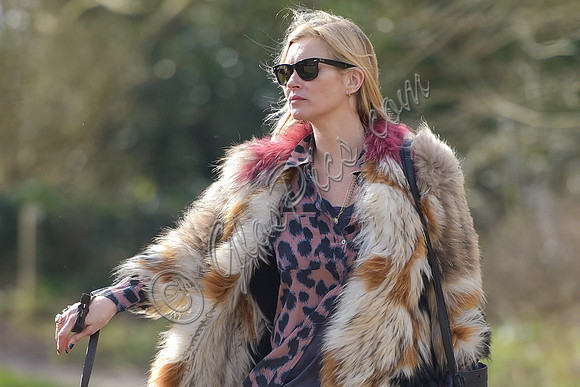 Kate Moss wearing Isabel Marant fur jacket and suede ankle boots with her dog Archie