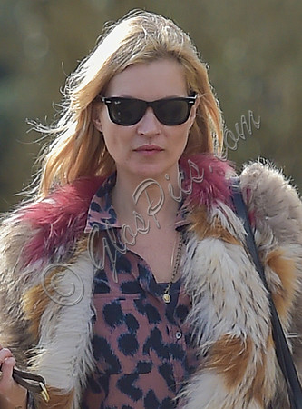 Kate Moss wearing Isabel Marant fur jacket and suede ankle boots with her dog Archie