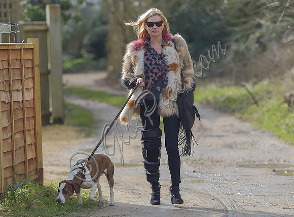 Kate Moss wearing Isabel Marant fur jacket and suede ankle boots with her dog Archie