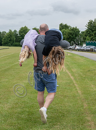 Mike Tindall carrying daughters Mia and Lena over each shoulder