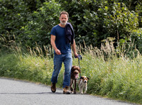 Andrew Lincoln dressed casually walking his two dogs