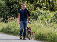Andrew Lincoln dressed casually walking his two dogs