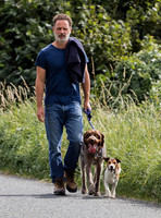 Andrew Lincoln dressed casually walking his two dogs
