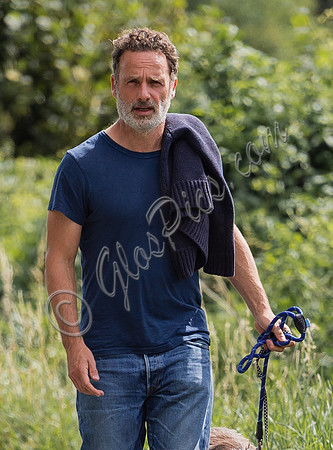 Andrew Lincoln dressed casually walking his two dogs