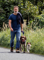 Andrew Lincoln dressed casually walking his two dogs