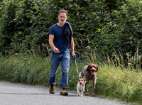 Andrew Lincoln dressed casually walking his two dogs