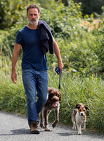 Andrew Lincoln dressed casually walking his two dogs