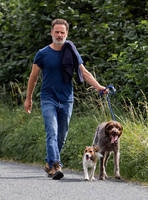 Andrew Lincoln dressed casually walking his two dogs