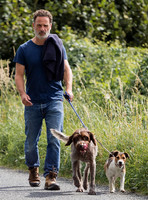 Andrew Lincoln dressed casually walking his two dogs