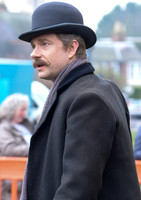 Head shot side view of Martin Freeman wearing Derby hat