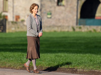 Jenny Seagrove in handcuffs wearing calf length skirt and thick woolly stockings