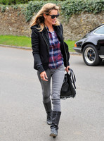 wearing trademark grey skinny jeans, black boots and a pair of Ray-Ban Wayfarer sunglasses, striped 'T', plaid shirt, hoodie with tailored jacket,  carrying Genevieve Jones fringed bag