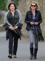wearing trademark grey skinny jeans, black boots and a pair of Ray-Ban Wayfarer sunglasses, striped 'T', plaid shirt, hoodie with tailored jacket, carrying Genevieve Jones fringed bag, with unidentif