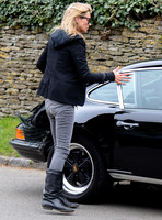 wearing trademark grey skinny jeans, black boots and a pair of Ray-Ban Wayfarer sunglasses, teamed up with layered look comprising of blue and white striped 'T', plaid shirt, hoodie with tailored jac