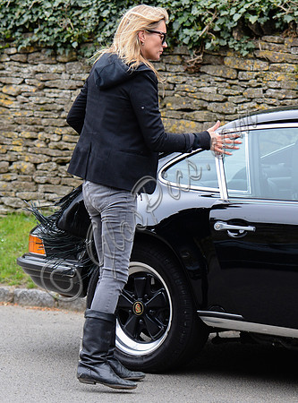 wearing trademark grey skinny jeans, black boots and a pair of Ray-Ban Wayfarer sunglasses, teamed up with layered look comprising of blue and white striped 'T', plaid shirt, hoodie with tailored jac