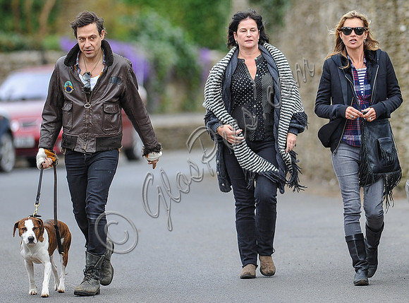 full length walking  towards camera, Jamie Hince with Archie on lead, Kate Moss and friend alongside.