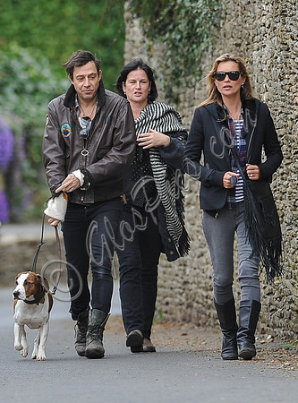 full length walking  towards camera, Jamie Hince with Archie on lead, Kate Moss and friend alongside.
