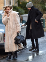 Kate Moss in calf length faux fur coat giggling with Jefferson Hack in background.