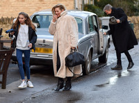 Kate Moss in calf length faux fur coat giggling with Jefferson Hack in background.