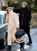 Kate Moss in calf length faux fur coat giggling with Jefferson Hack in background.