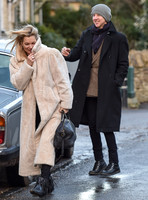 Kate Moss in calf length faux fur coat giggling with Jefferson Hack in background.