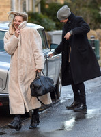Kate Moss in calf length faux fur coat giggling with Jefferson Hack in background.