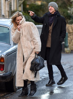 Kate Moss in calf length faux fur coat giggling with Jefferson Hack in background.