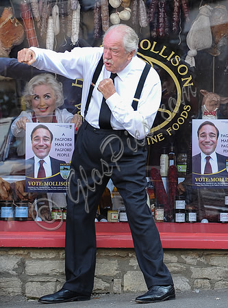 Sir Michael Gambon in fighting spirit,outside the deli with Hetty Banes looking out from window