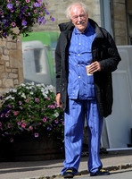 Sir Michael Gambon as Howard Mollison wearing blue pyjamas and monogrammed slippers