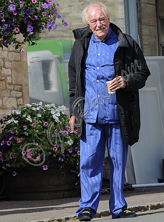 Sir Michael Gambon as Howard Mollison wearing blue pyjamas and monogrammed slippers