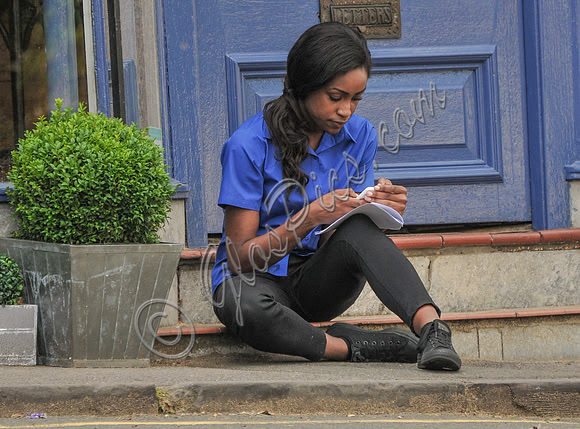 Simona Brown sat on step in front of Blue door