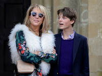 waist up shot od Georgia Daventry wearing brightly coloured blouse with white shaggy faux fur gilet with Damien Hurley in blue and white stripe shirt, blue blazer and jumper.