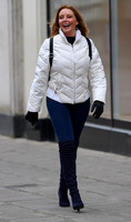 Carol Vorderman in skin tight jeans, with off white padded jacket over