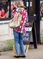 Kate Moss with loose hair knot, wearing denims, multi coloured top and ballet pumps