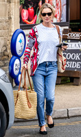Kate Moss with loose hair knot, wearing denims, multi coloured top and ballet pumps