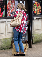 Kate Moss with loose hair knot, wearing denims, multi coloured top and ballet pumps