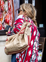 Kate Moss with loose hair knot, wearing denims, multi coloured top and ballet pumps