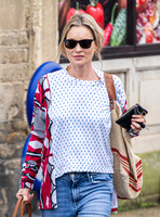 Kate Moss with loose hair knot, wearing denims, multi coloured top and ballet pumps