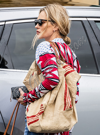 Kate Moss with loose hair knot, wearing denims, multi coloured top and ballet pumps