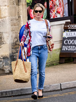 Kate Moss with loose hair knot, wearing denims, multi coloured top and ballet pumps