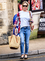Kate Moss with loose hair knot, wearing denims, multi coloured top and ballet pumps