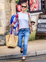 Kate Moss with loose hair knot, wearing denims, multi coloured top and ballet pumps