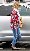 Kate Moss with loose hair knot, wearing denims, multi coloured top and ballet pumps