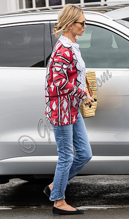 Kate Moss with loose hair knot, wearing denims, multi coloured top and ballet pumps