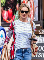 Kate Moss with loose hair knot, wearing denims, multi coloured top and ballet pumps