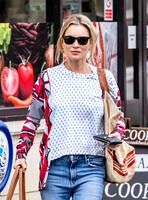 Kate Moss with loose hair knot, wearing denims, multi coloured top and ballet pumps