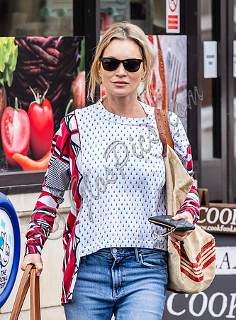 Kate Moss with loose hair knot, wearing denims, multi coloured top and ballet pumps